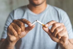 man breaking a cigarette depicting quitting smoking