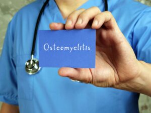 doctor holding up a card that says osteomyelitis